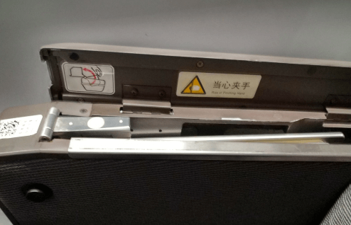 開蓋后可以看到一塊金屬板，這個就是藏起來的高鐵小桌板，向上將其拉出。